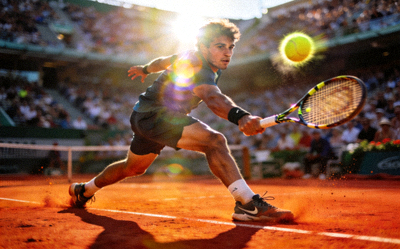 网球大满贯法网公开赛，球员在红土场地上奋力救球的动态瞬间